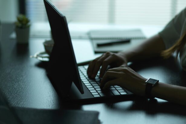 A woman uses a laptop in a dimly lit room.