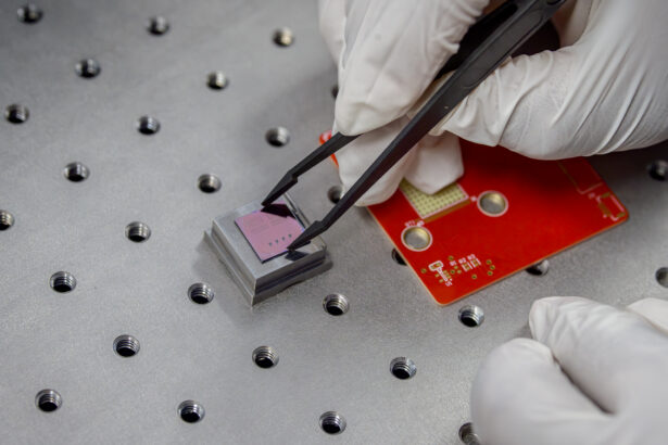 A researcher uses precision tweezers to position a device during laboratory testing and packaging.